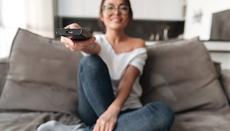 A Woman Using a Universal Remote Control